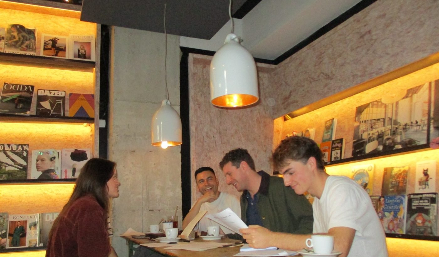 People talking and laughing around a table at a TIME TO LIVE meetup in Madrid